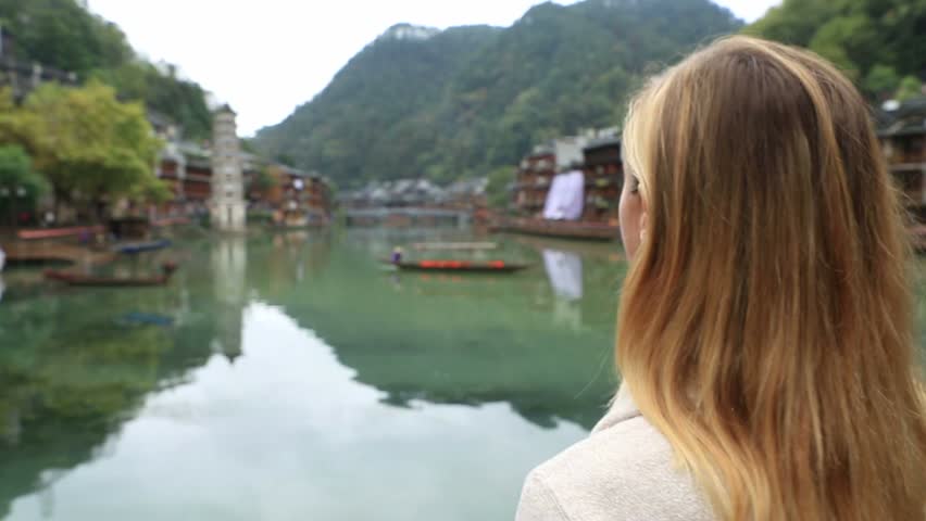 Young woman in Chinese village makes heart shape finger frame