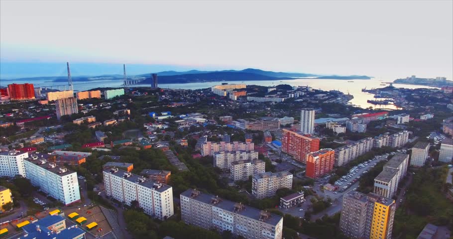 Panoramic aerial view of Vladivostok city. Russian bridge and Russian island are on the background. Beautiful sunset. Russia
