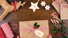Christmas gift wrapping overhead in rustic theme with brown Kraft paper, string and natural ornaments