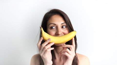 Fun woman making banana smile on white background isolated