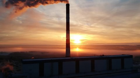 Aerial rising above power plant in winter sunrise
