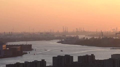 Nieuwe Maas in Evening Light with ships on the river, industrial areas and the harbor of Rotterdam in the Netherlands.