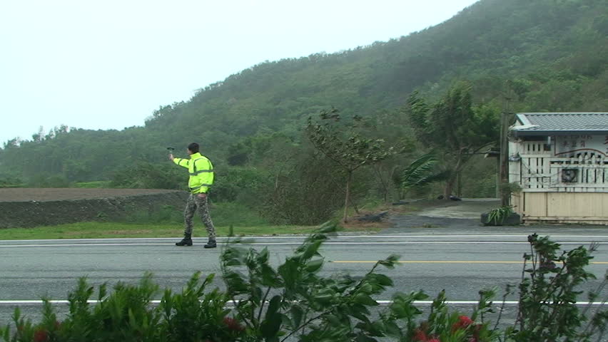 HUALIEN, TAIWAN - AUGUST 2009: Storm chaser measures strong winds as typhoon