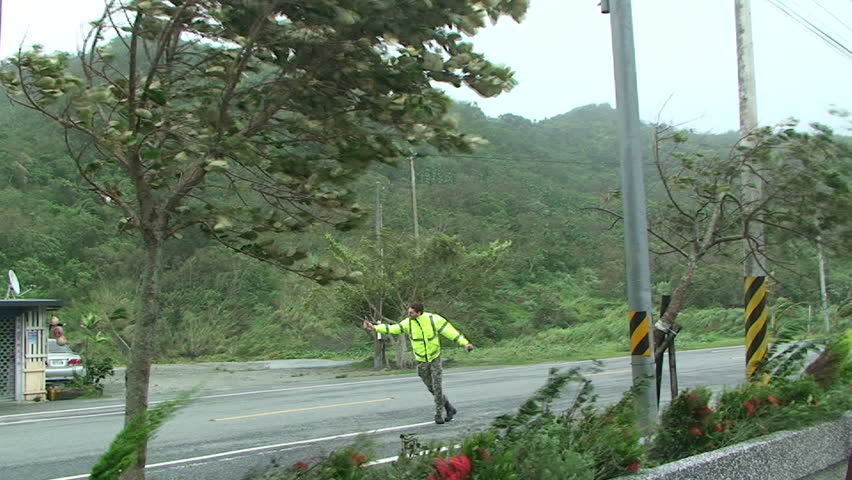 HUALIEN, TAIWAN - AUGUST 2009: Storm chaser measures strong winds as typhoon Morakot hits Taiwan.