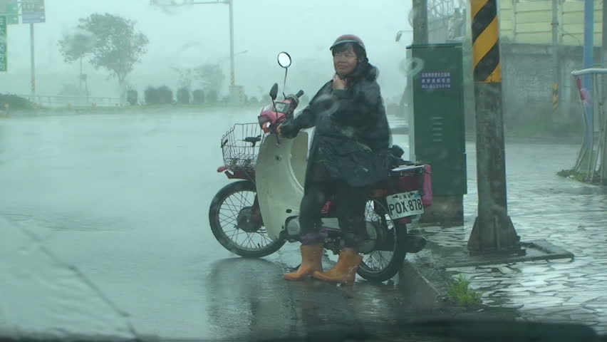 HUALIEN, TAIWAN - AUGUST 2009: Person Caught Out In Rain And Wind As Typhoon