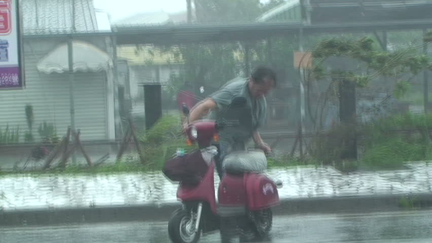 HUALIEN, TAIWAN - AUGUST 2009: Man lashed by ferocious wind and rain of typhoon