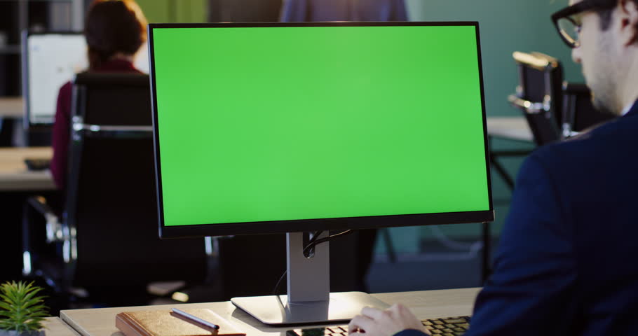 Businessman working on the PC computer and typing on the keyboard in the office. Rear view. Computer green screen, chroma key. Indoor | Shutterstock HD Video #32941561
