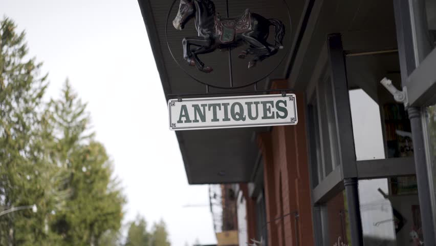 Backing away from “Antiques” store sign with child’s rocking horse to reveal a small