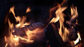 Closeup of bright burning fire in fireplace. Christmas (Xmas) or New Year shiny blurry bokeh video background. Real time full hd video footage.