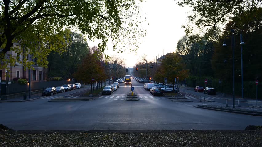turning on the street lamps after the sunset in Milan on the avenue and pedestrian avenue