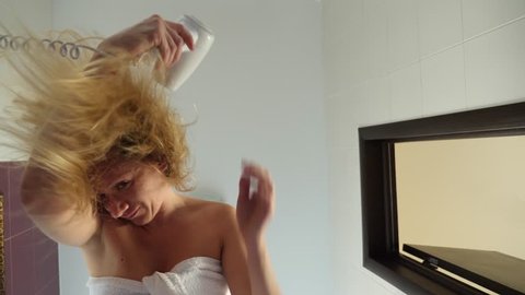 Slow movement of female dry wet hair. A female woman uses a hairdryer in the bathroom. 4k