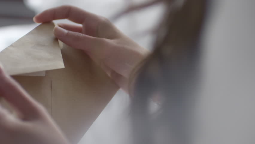 Mid-section of unrecognizable woman opening and reading handwritten letter from lover | Shutterstock HD Video #32961937
