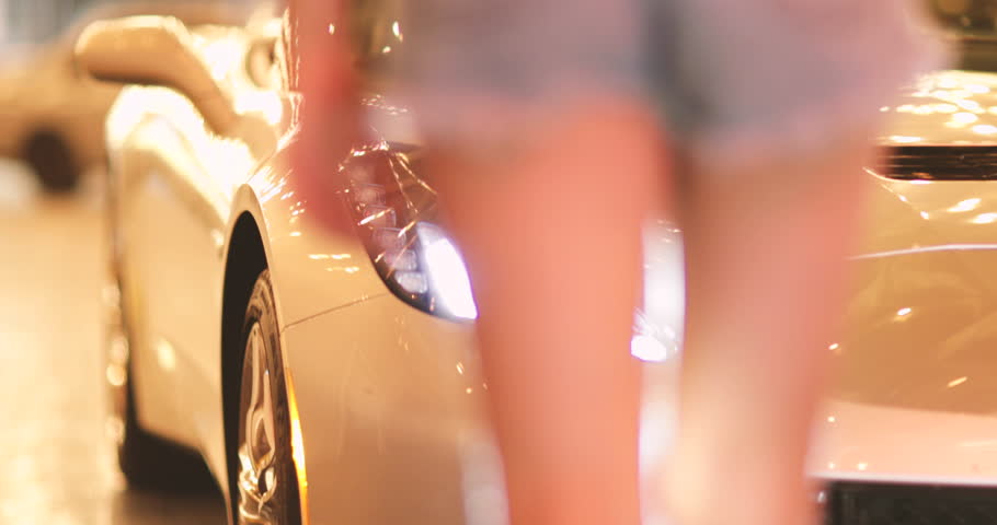 Attractive woman at night sitting on car