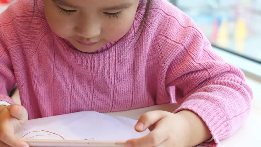one little girl using smart phone indoor