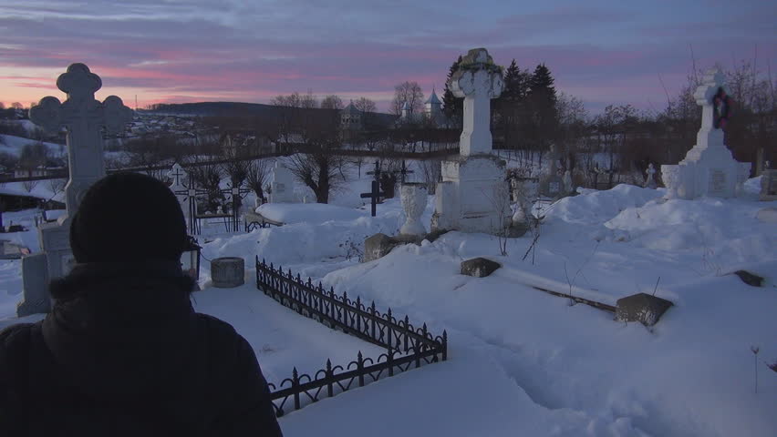 Young woman rest in cemetery during winter time