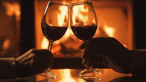 Cinemagraph - Young couple have romantic dinner with wine over fireplace background. Romantic concept . Motion Photo.