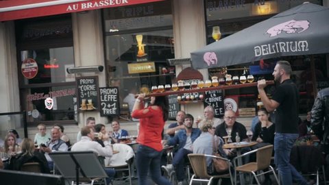 Brussels, Belgium - August 26, 2017: People in a bar having a drink and walking on a street in Brussels, Belgium