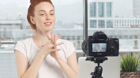 Cheerful female blogger recording video.