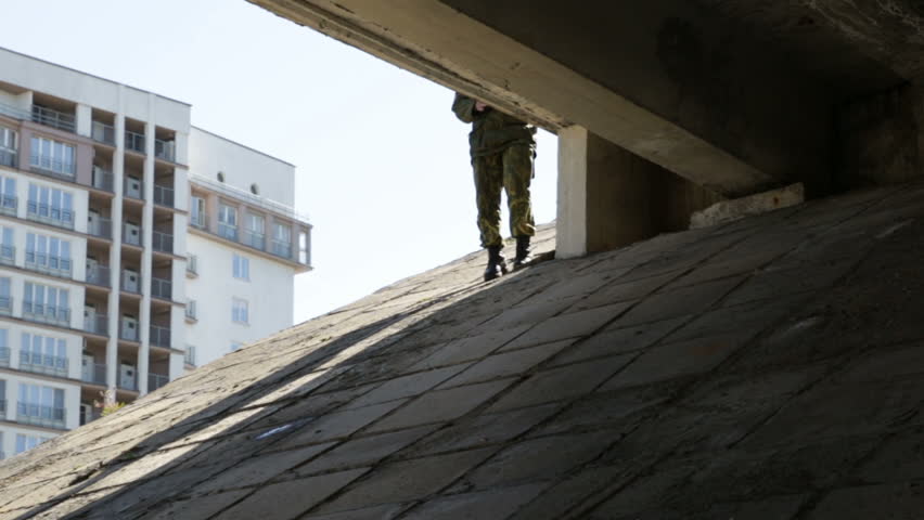 Man in uniform on duty under the road bridge, zoom in. Outdoor, day, spring, sun