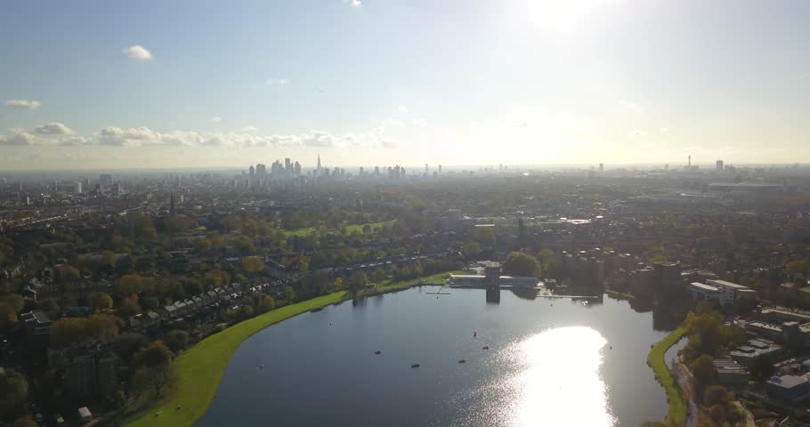 Drone flight (aerial footage) over the west reservoir at Woodberry Down, North London.  London skyline (Gherkin and Shard) can be seen on the horizon as drone flies towards the centre of the city.