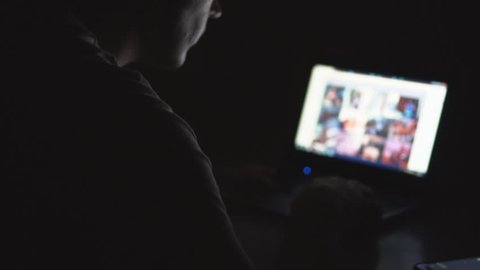 Man secretly watching porn sites at night.
