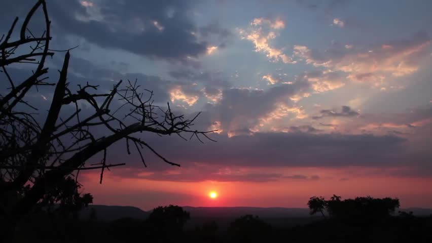 A time-lapse of an African sunset. The clouds moving fast toward, the