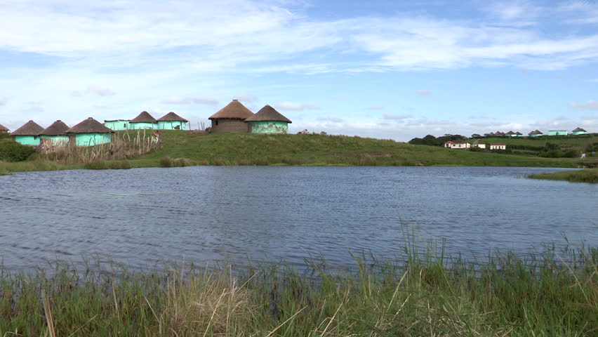 A wide shot of Xhosa huts next to a dam in the Transkei.
