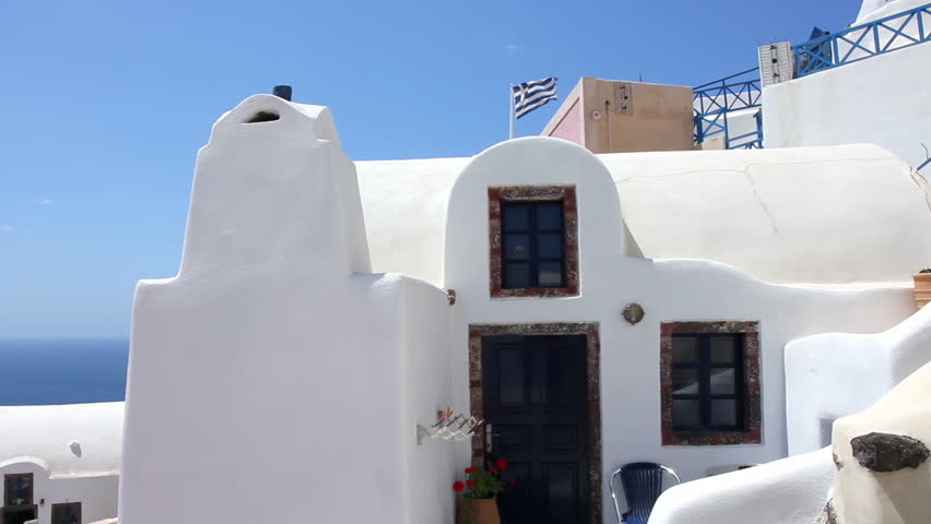 A beautiful traditional architecture of houses and Greece flag. Thira Island - Santorini Greece.