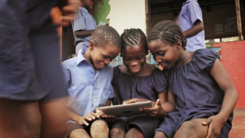 4k of African school students / pupils using tablet computer during lunch break at school.