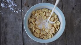Milk pouring into bowl of cereal in slow motion,breakfast food concept