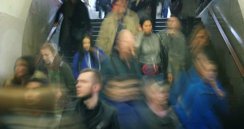 Crowds of people exiting stairway in subway station, blurred in motion. Busy city life. 4K UHD timelapse.