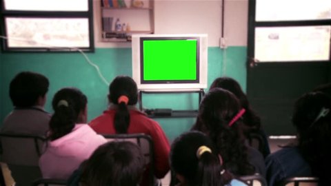 Students in Classroom Watching Old TV with Green Screen. You Can Replace Green Screen with the Footage or Picture you Want with “Keying” effect in After Effects  (check out tutorials on YouTube).
