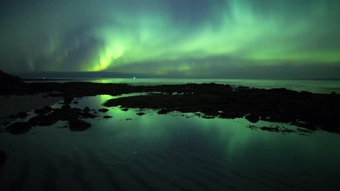 Aurora borealis and stars reflecting in calm ocean tidal pool water Iceland prores
