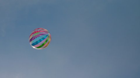 A beautifully colored beach ball enters and leaves the blue sky in slow motion.

Shot at 50 frames per second.