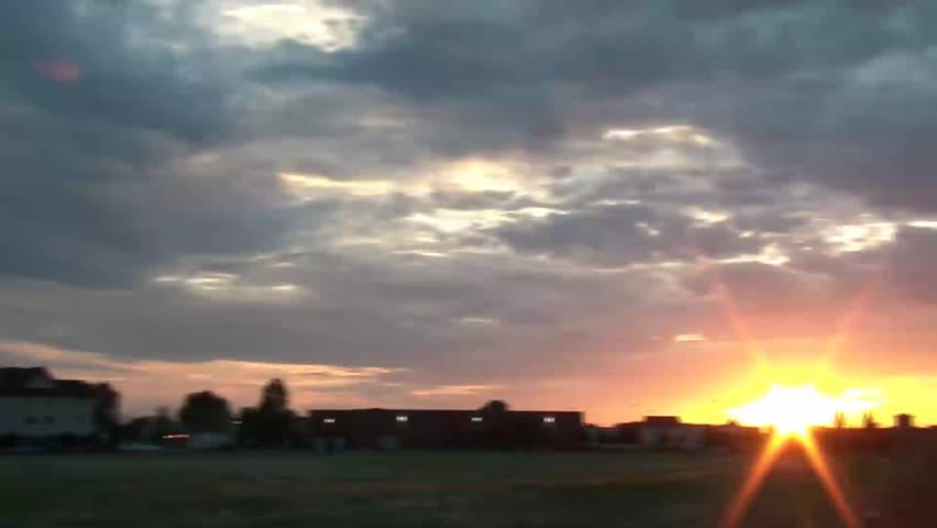 Girl shooting sunset pictures and then shows off her various images in lcd screen, talks to camera.