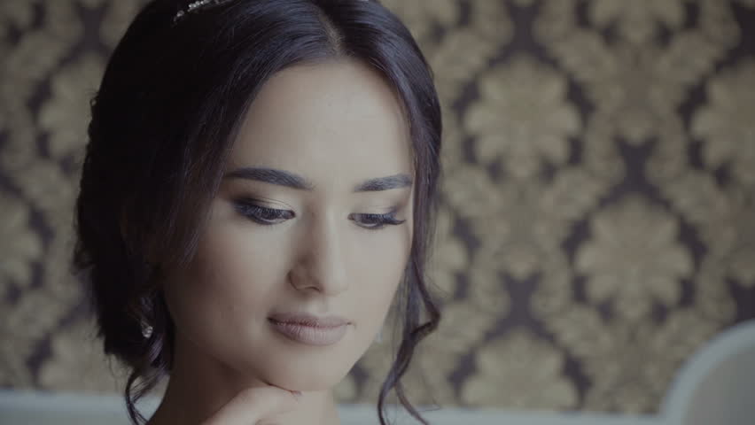Portrait of beautiful young woman with long brown hair in wedding dress