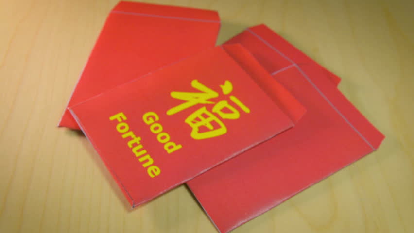 The red envelope or hong bao is used for giving money during the Spring Festival, or Chinese New Year in China and Taiwan. Envelope with the chinese words meaning Good fortune on it, and dollar bills.