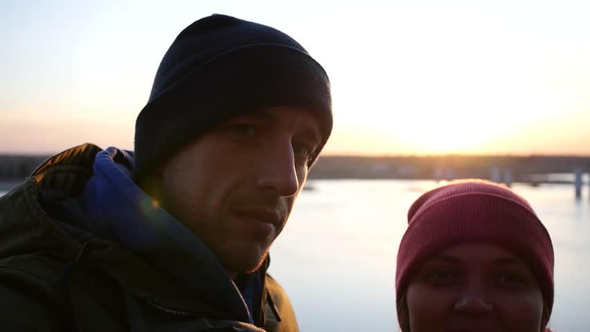 Young Couple Man and Woman Photographed by the River on the Background of the Sunset in the Autumn, Show in the Chamber of the Sacred Victory. low motion, 1920x1080, full hd