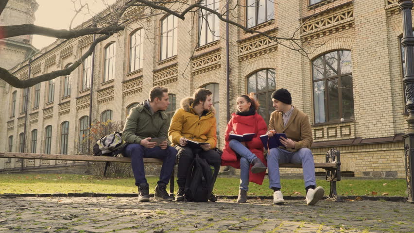 Four students sits at the bench in park