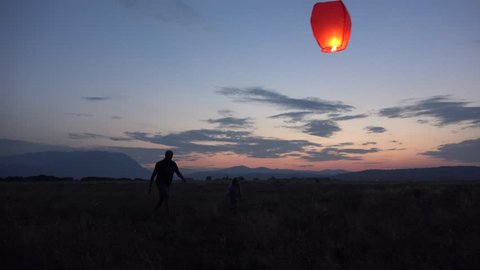 4K Happy Family Lifting Chinese Lantern on Sky Playing Outdoor Sunset, Mountains
