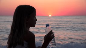 Child Drinking Water on Beach at Sunset, Girl Watching Sea Waves on Seaside 4K