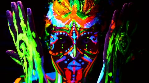 Close-up Emotions of young bodyarted avatar girl in ultraviolet light. Face of woman in color light.