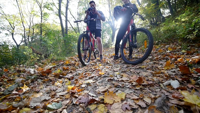 A woman and a man riding a bike an autumn day