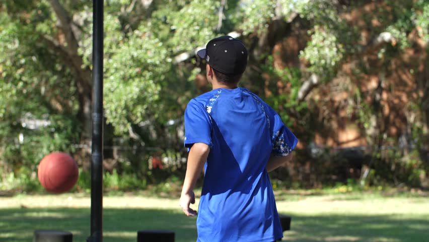 Children play basketball kid throwing basketball to the hoop backyard of school