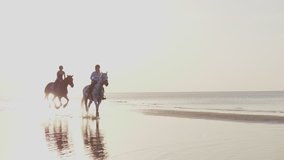Two women riding horses on a beach - Powered by Shutterstock - Get 15% off with code: PIKWIZARD15