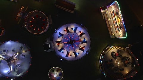 Bird's Eye View of Fairground Rides at Night with Flashing Lights 