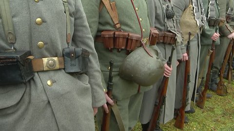 German soldiers of the old Kaiser's army standing in the ranks, holding rifles in their hands,helmets fastened to belts. Reconstruction of the First World War of 1914-1918, close-up.