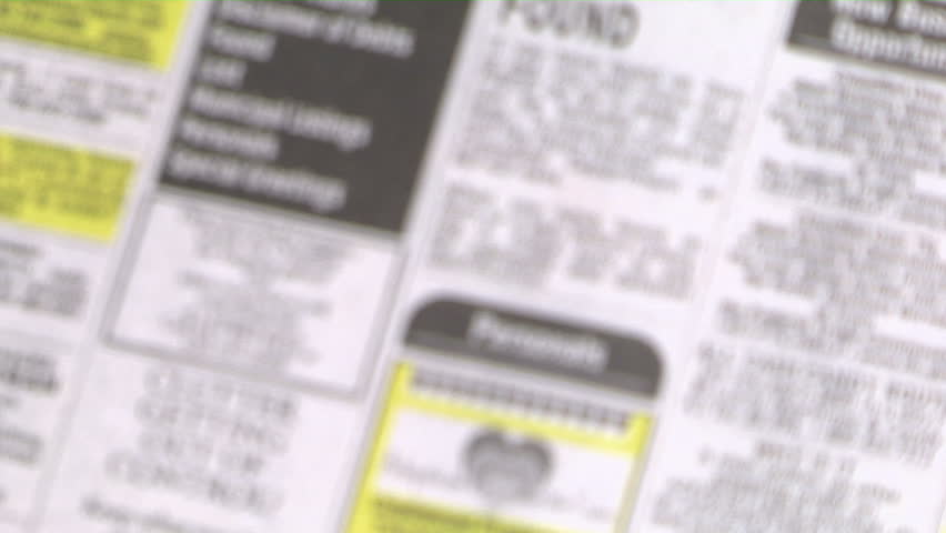 magnifying glass focuses on the personals section of the newspaper