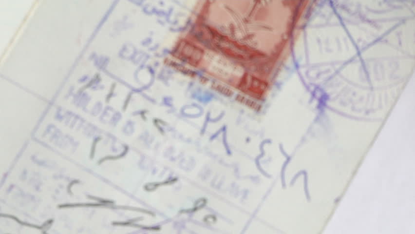 magnifying glass focuses on a stamp from saudia arabia inside a passport