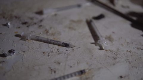 Used Needles For Heroin And Drugs On Dirty Floor Of Abandoned Slum. Homeless And Poverty, Social Issues In Ghetto.
